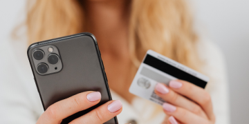 Persona controlla movimenti sospetti sul conto dopo clonazione della carta di credito