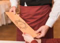 Cliente controlla un menù con prezzi non esposti prima di pagare il conto in un ristorante